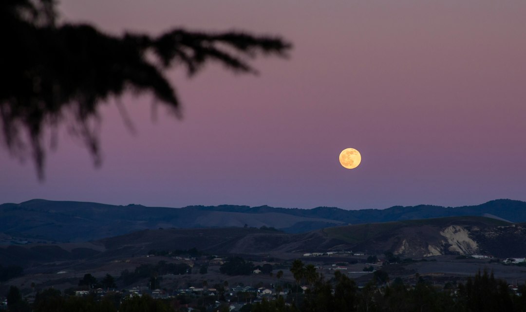 Luna sobre un paisaje montañoso al anochecer